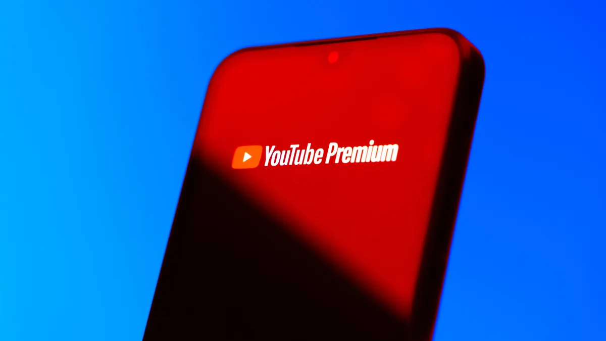 Smartphone on blue background showing Youtube Premium logo