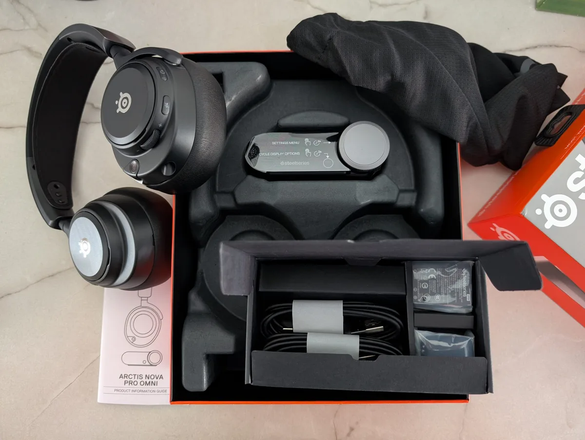 The SteelSeries Arctis Nova Pro Wireless box is open, displaying the headset, charging base, and a'Quick Setup Guide'.