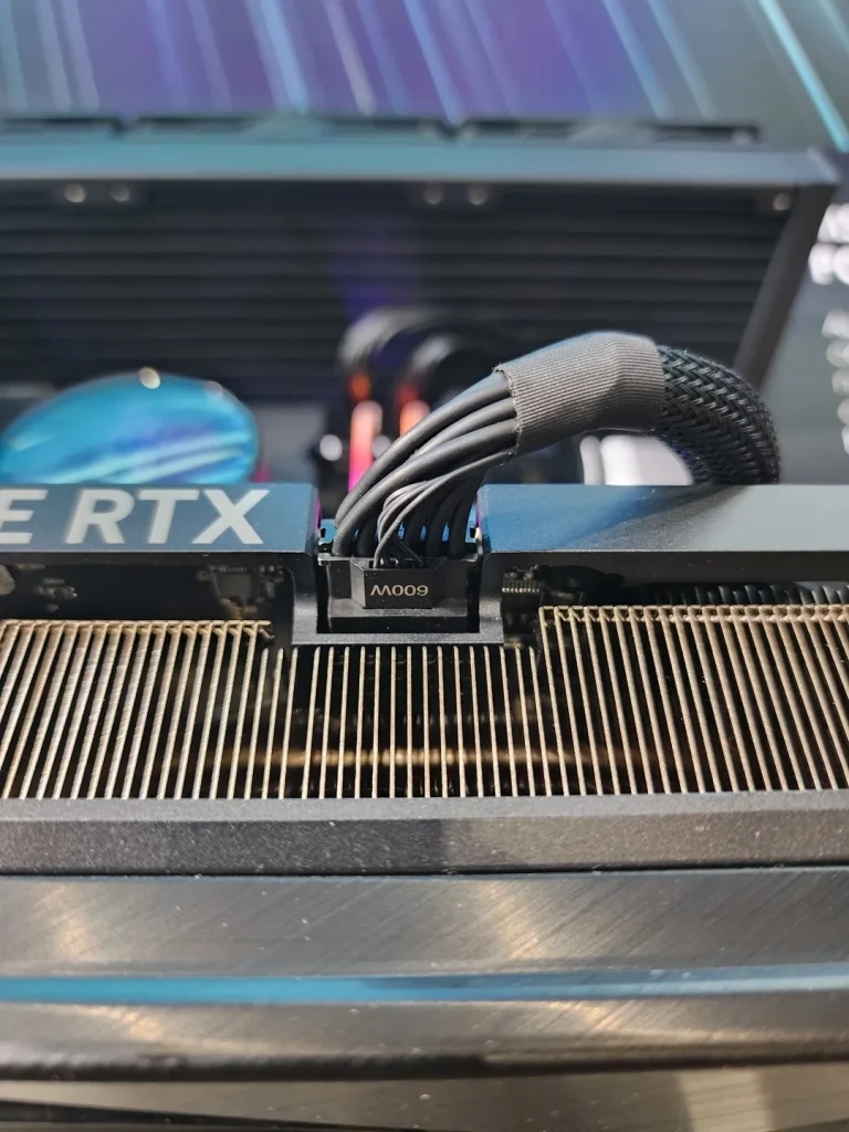 A close-up of an NVIDIA GeForce RTX graphics card shows a 600W power connector attached.