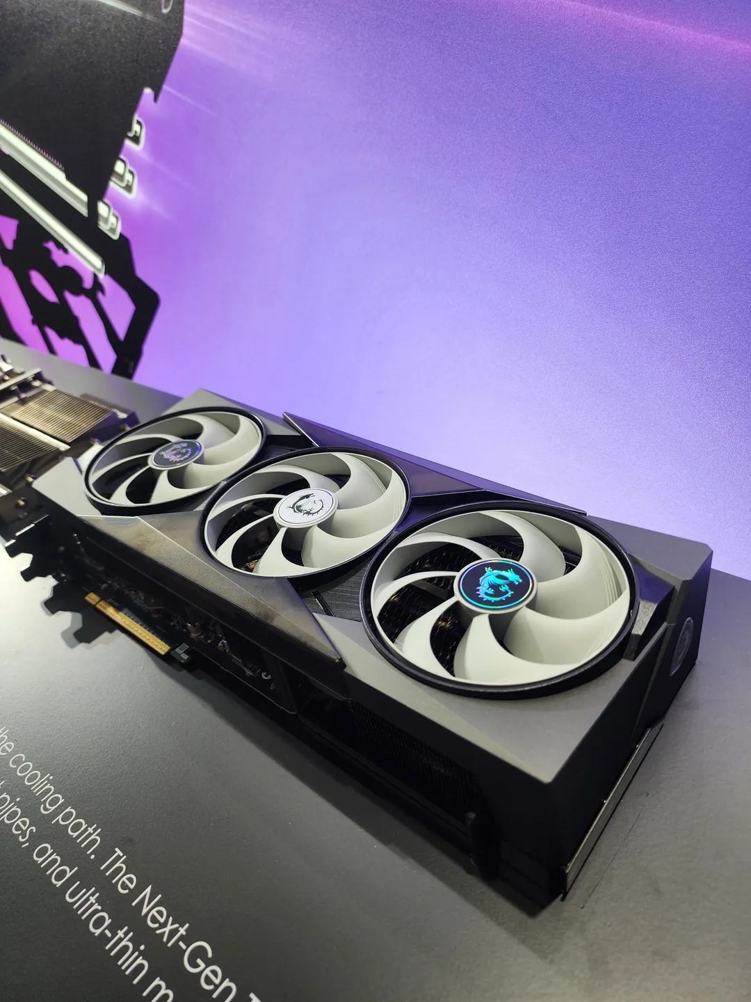 An MSI graphics card with triple fans is displayed on a black surface with part of the text reading'The Next-Gen.'