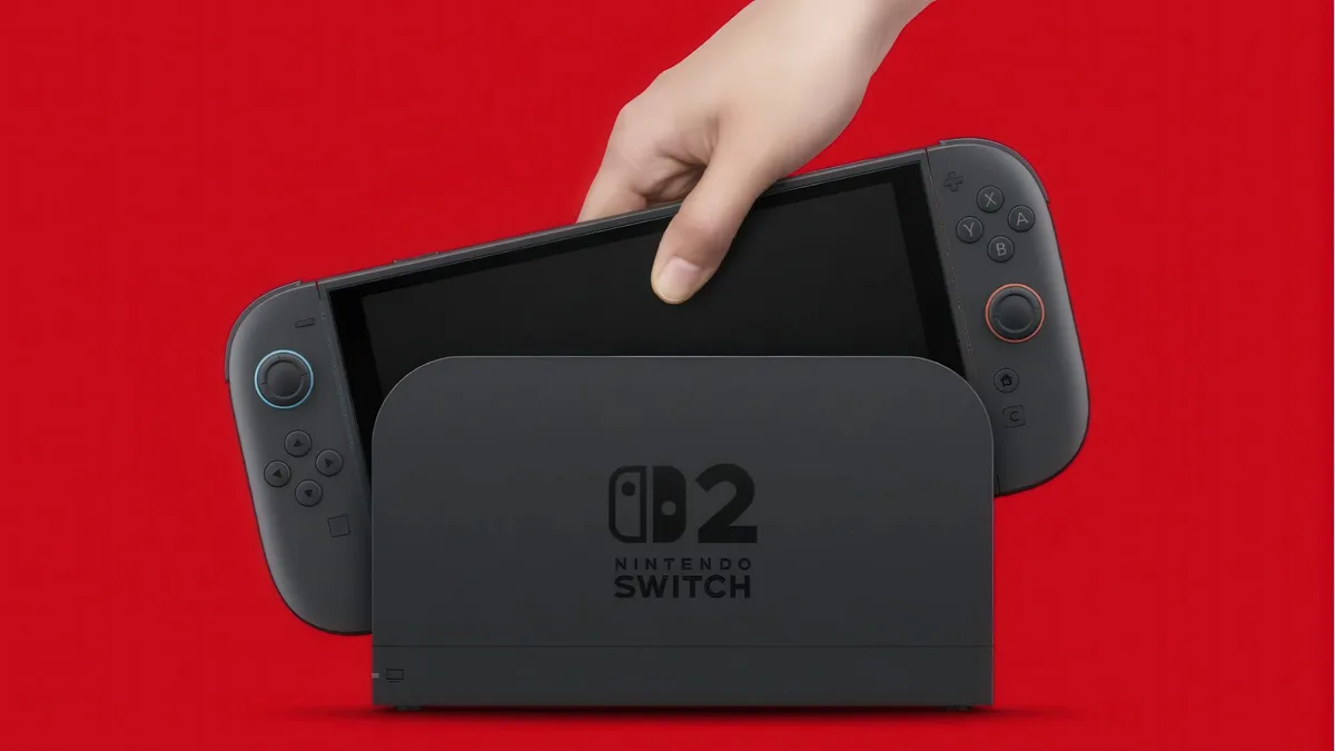 A hand places a Nintendo Switch 2 OLED console into a charging dock labeled with'Nintendo Switch 2' against a red background.