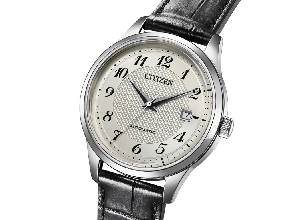 Citizen Caliber — Front view of the Citizen NJ0250-01B automatic watch with a silver dial, black Arabic numerals, date window, and black leather strap.