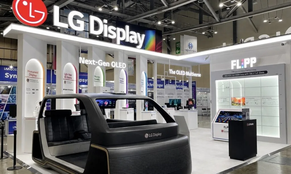 FLiPP fotolitografía OLED fabricación — The LG Display booth showcases a'Next-Gen OLED' display and an interactive automotive interior concept with branded seating at a technology exhibition.