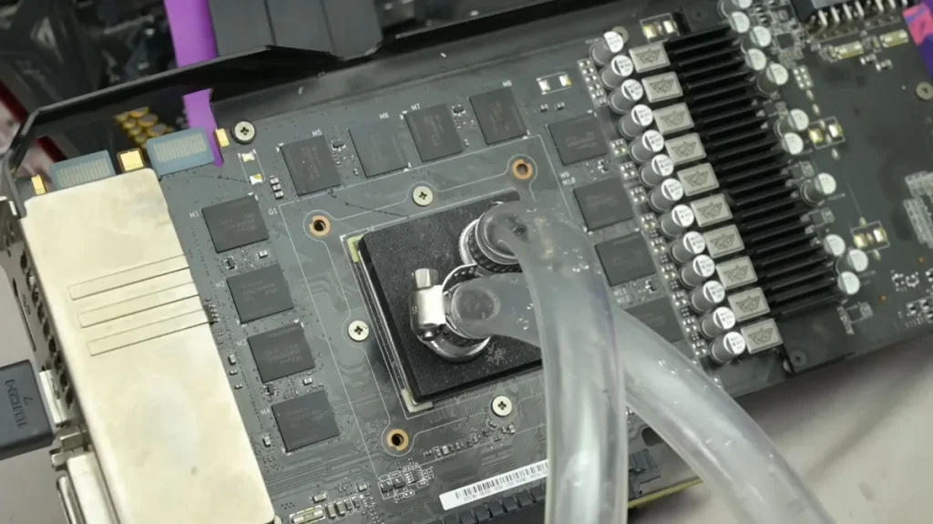 A disassembled GPU with visible circuitry and cooling pipes attached to the core area.