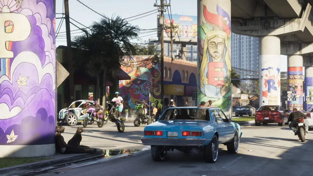 A street scene from Grand Theft Auto VI shows a blue car with the license plate 'EULA Y7' and people on motorcycles in a colorful, graffiti-decorated urban setting.