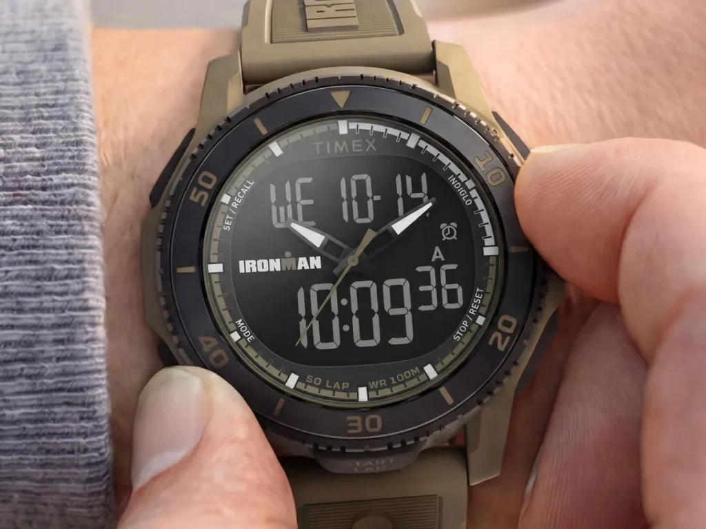 Sand-colored Timex Ironman Adrenaline ana-digi watch shown on a wrist, with a black bezel and digital display visible.