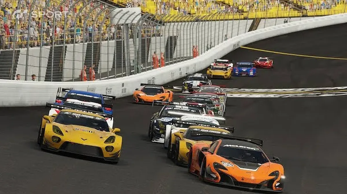 Un coche deportivo naranja lidera un grupo de coches en una curva peraltada junto a una grada llena en Gran Turismo Sport
