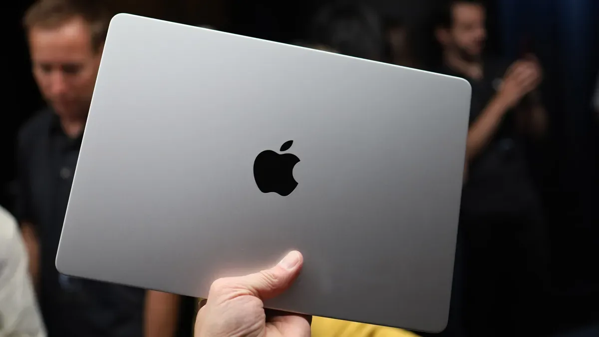 Tapa plateada de un MacBook con el logo de Apple en negro, sin iluminar