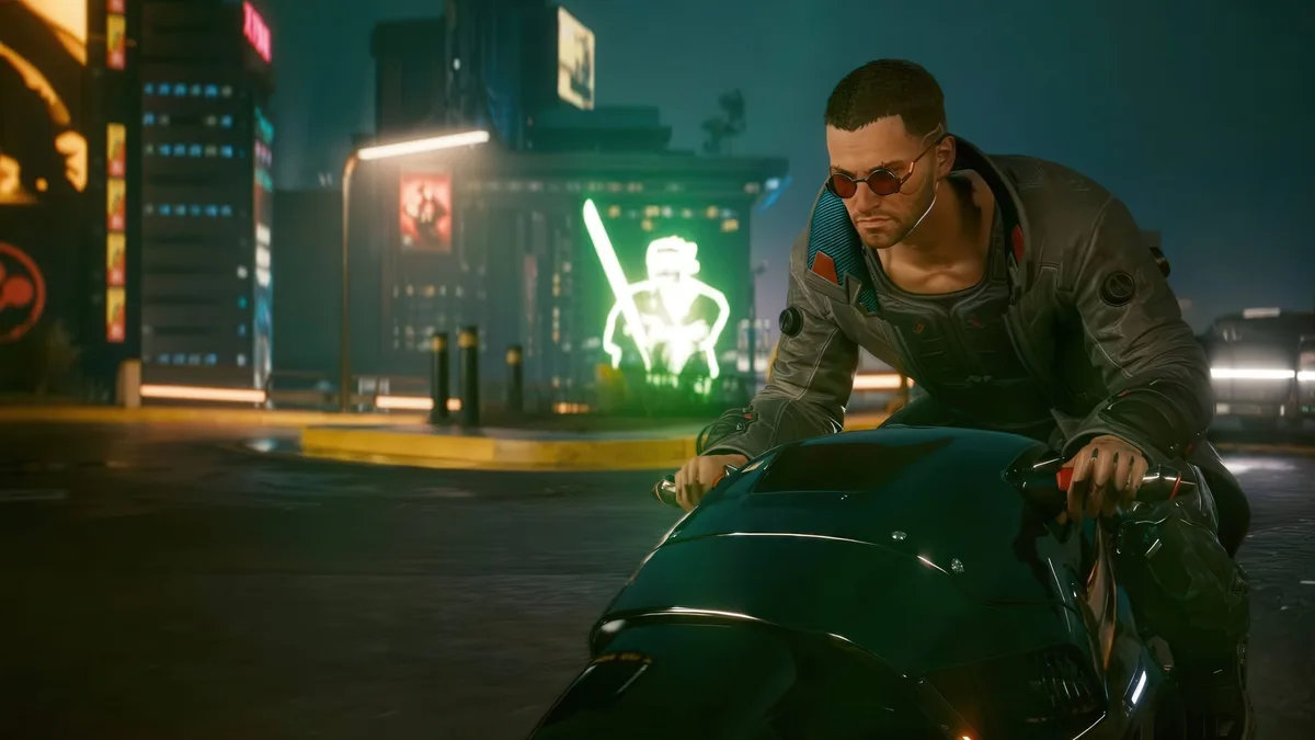 Personaje de Cyberpunk 2077 con gafas de sol en moto por una ciudad iluminada de neón