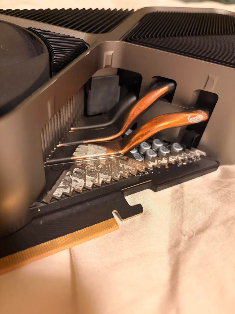 A close-up view of the cooling fins and heat pipes on an unbranded GPU with a PCI connector visible at the bottom.